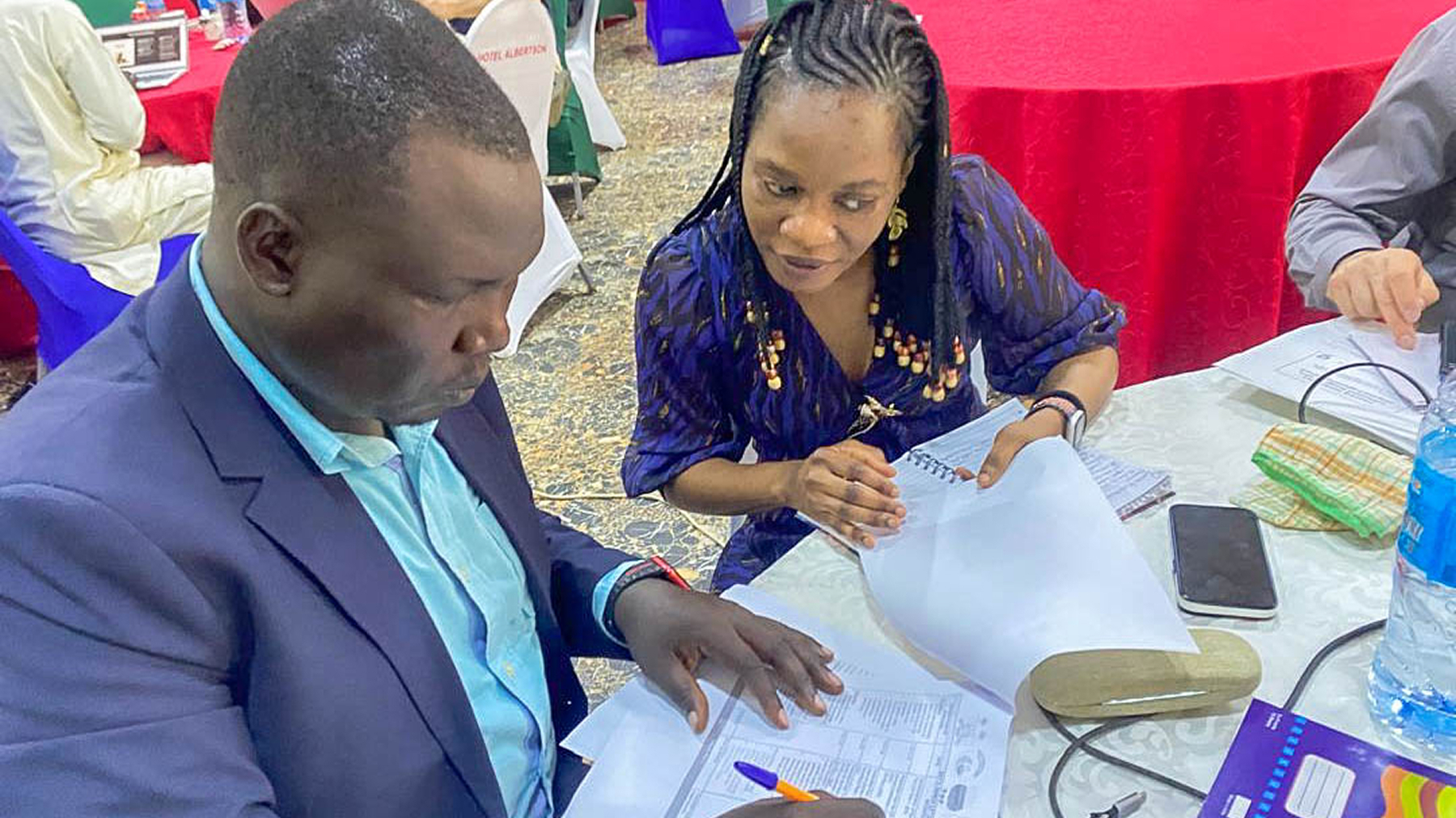 Two participants discuss and review documents.